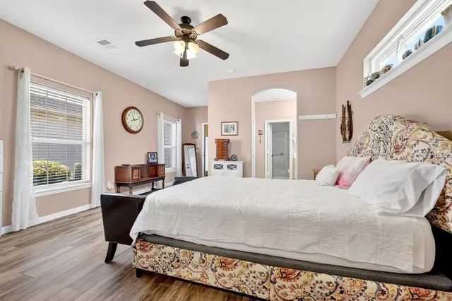 a bedroom with a large bed and wooden floor