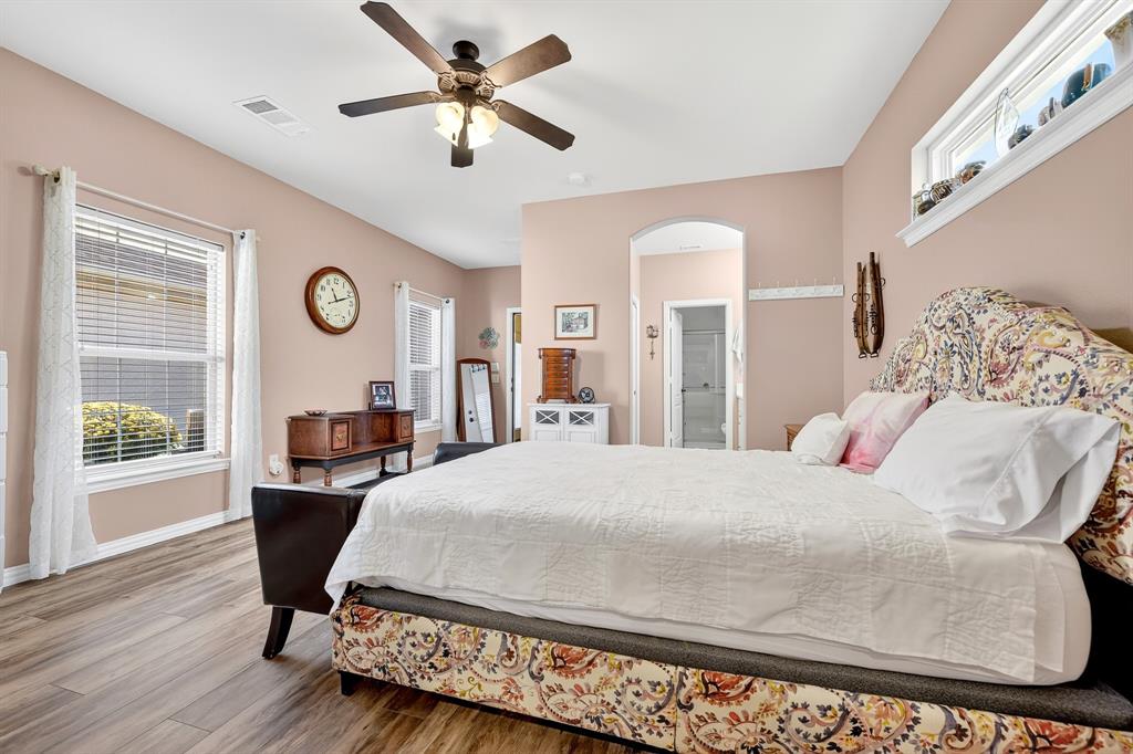 9813 Callaway Court Denton, TX 76207 - Photo 27 of 39 a bedroom with a large bed and wooden floor