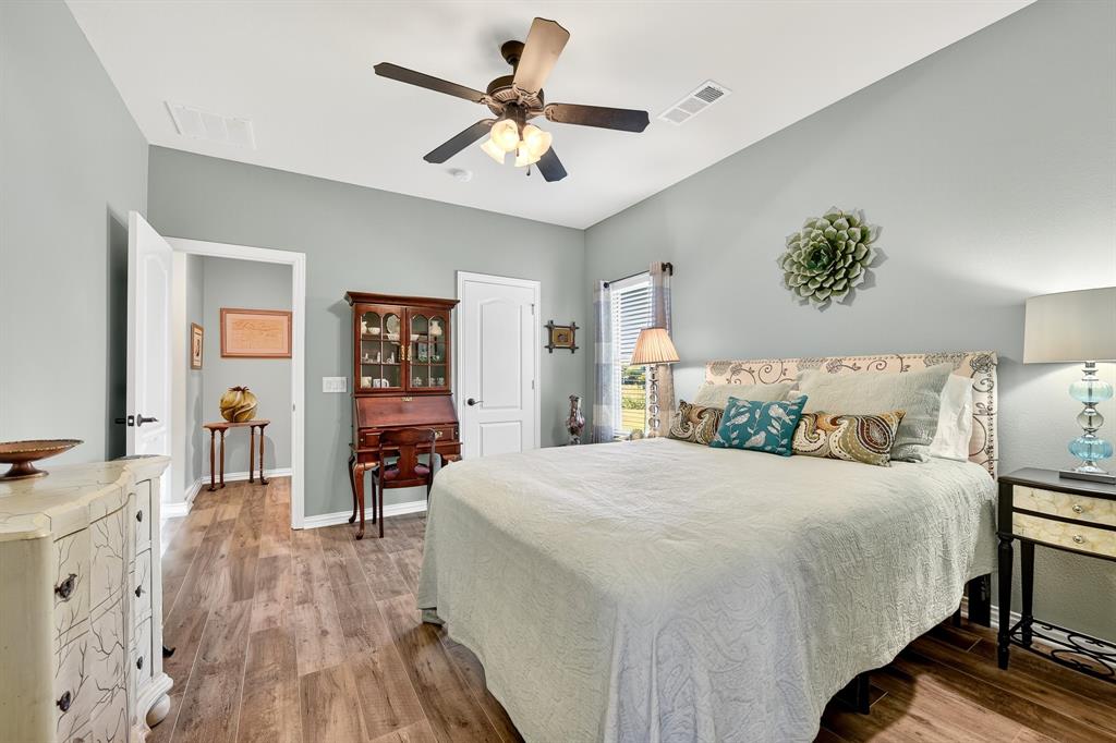 9813 Callaway Court Denton, TX 76207 - Photo 32 of 39 a bedroom with a bed and wooden floor