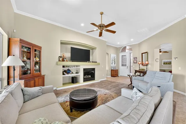 a living room with furniture a fireplace and a flat screen tv