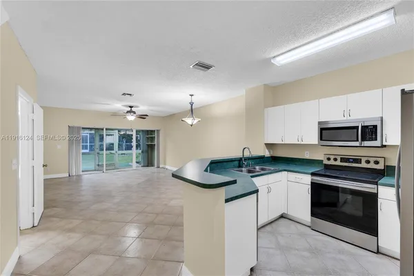 a kitchen with stainless steel appliances granite countertop a stove sink and cabinets