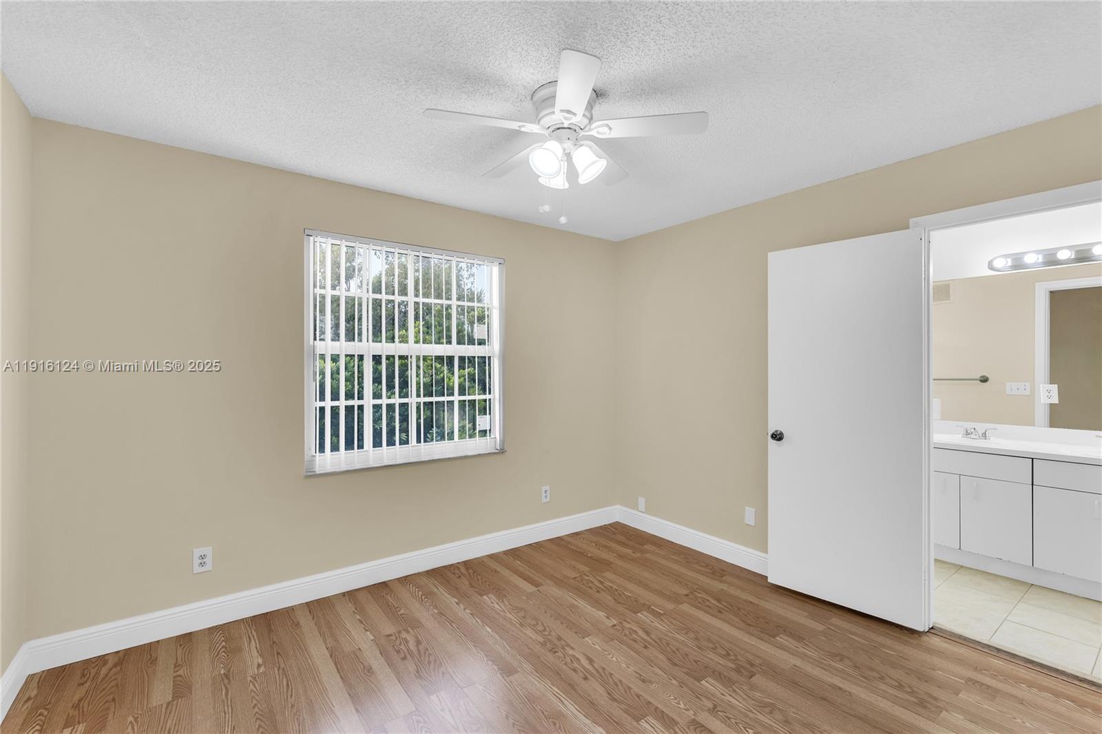 304 Southwest 120th Avenue, Unit 304 Pembroke Pines, FL 33025 - Photo 25 of 46 a view of an empty room with wooden floor and a window