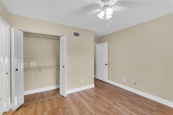 a view of an empty room with wooden floor
