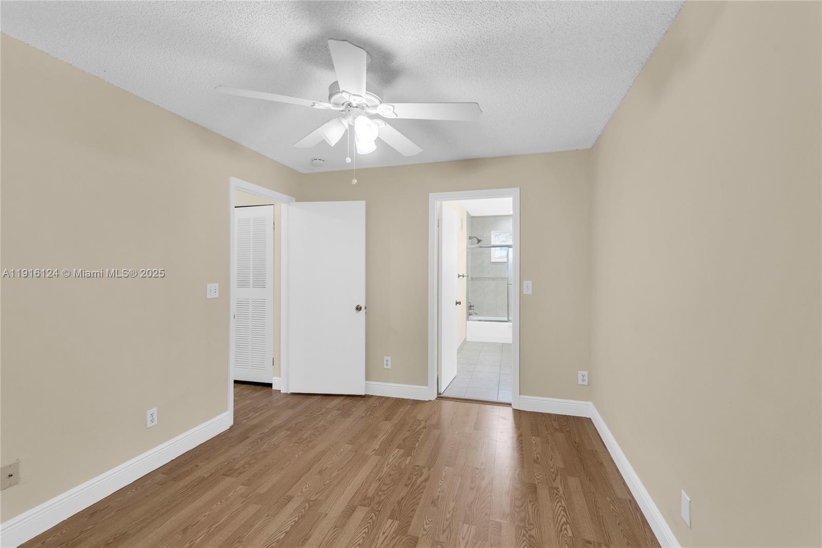 304 Southwest 120th Avenue, Unit 304 Pembroke Pines, FL 33025 - Photo 29 of 46 an empty room with wooden floor and fan