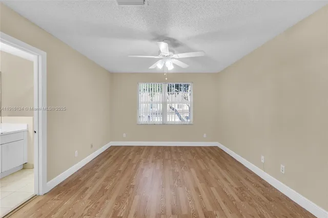 an empty room with wooden floor a ceiling fan and closet