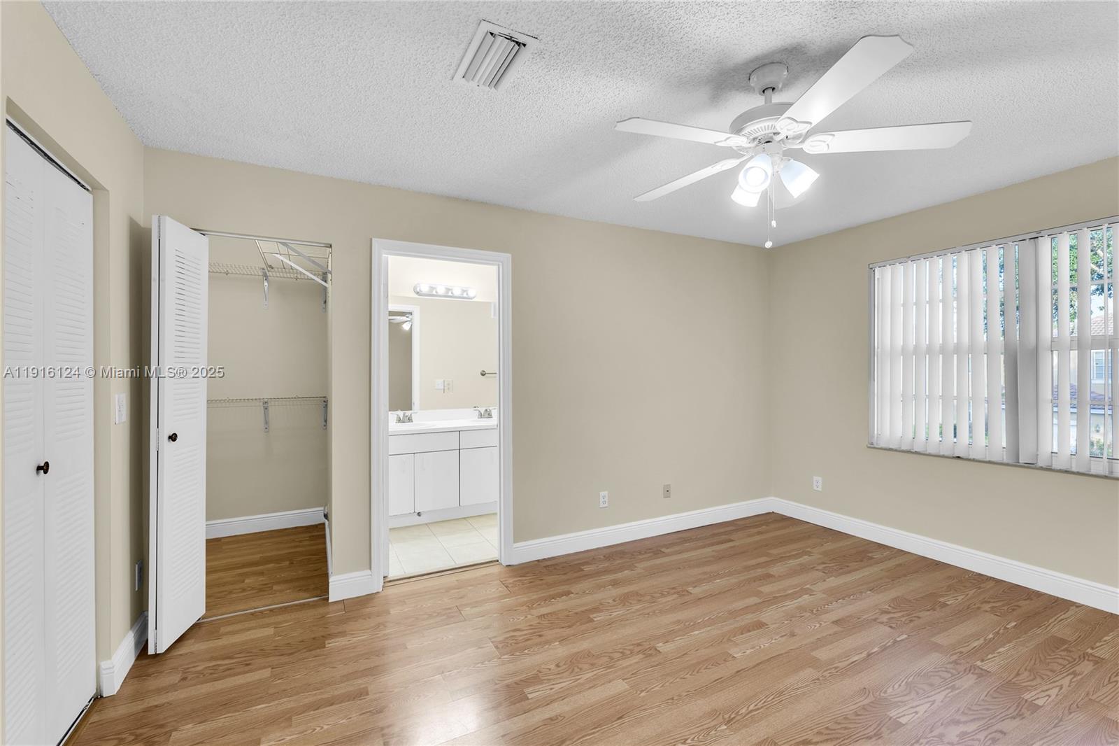 304 Southwest 120th Avenue, Unit 304 Pembroke Pines, FL 33025 - Photo 32 of 46 a view of an empty room with wooden floor and a window
