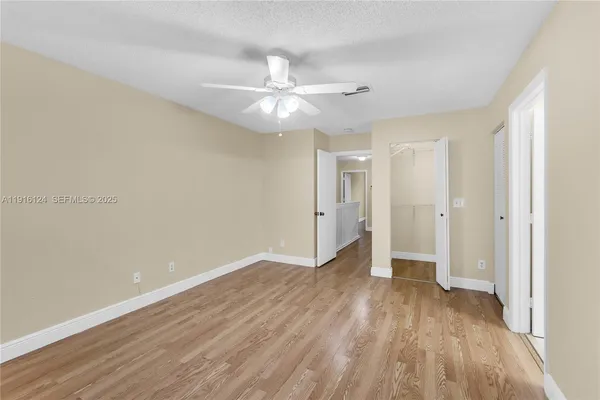 a view of a hallway with wooden floor and entryway