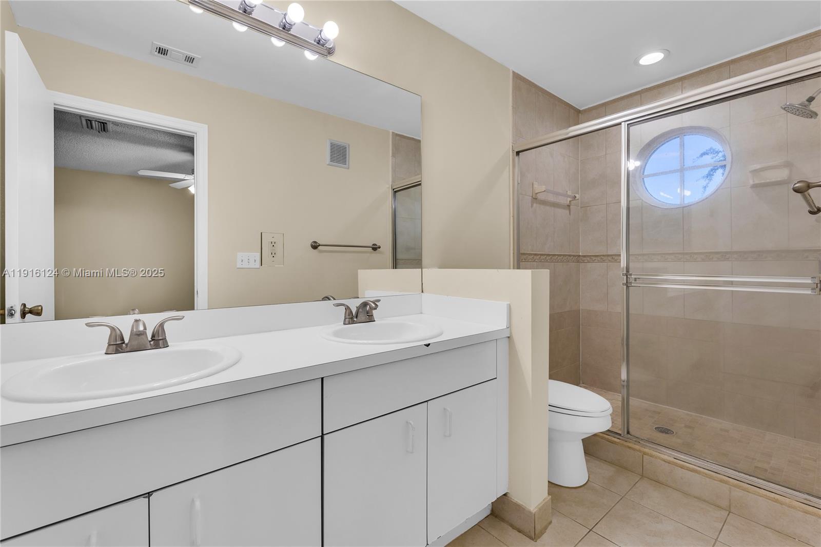 304 Southwest 120th Avenue, Unit 304 Pembroke Pines, FL 33025 - Photo 34 of 46 a bathroom with a toilet a sink and mirror