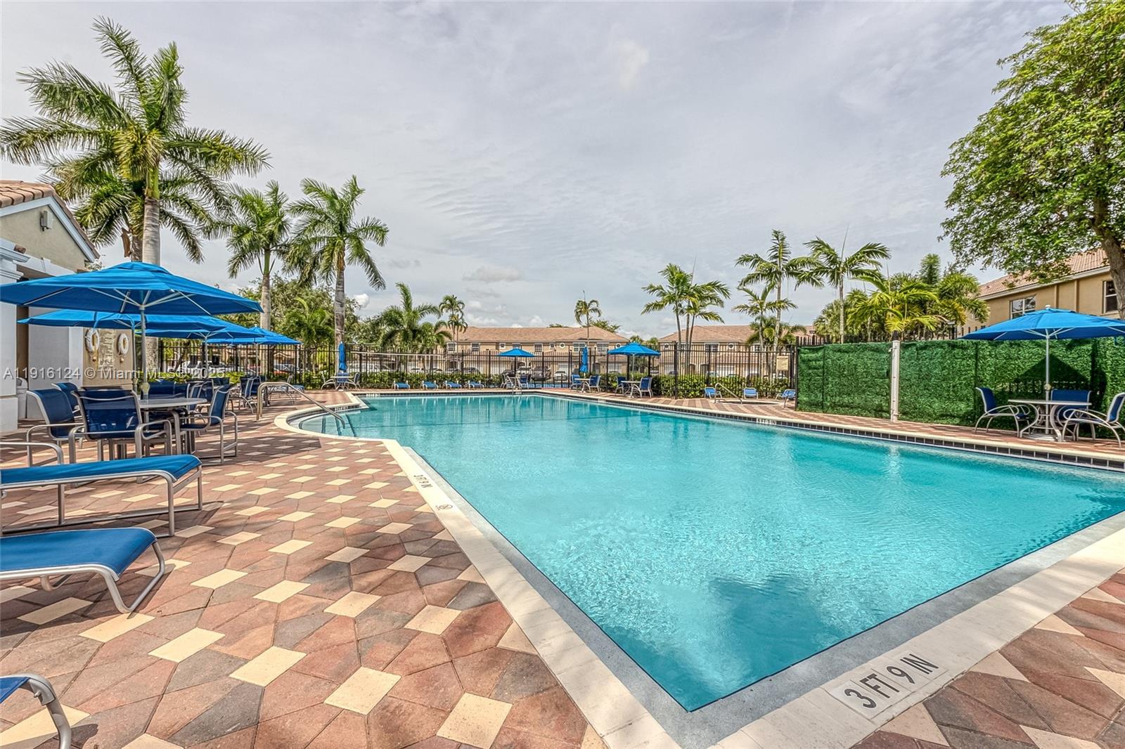 304 Southwest 120th Avenue, Unit 304 Pembroke Pines, FL 33025 - Photo 37 of 46 a view of a swimming pool with a table and chairs under an umbrella