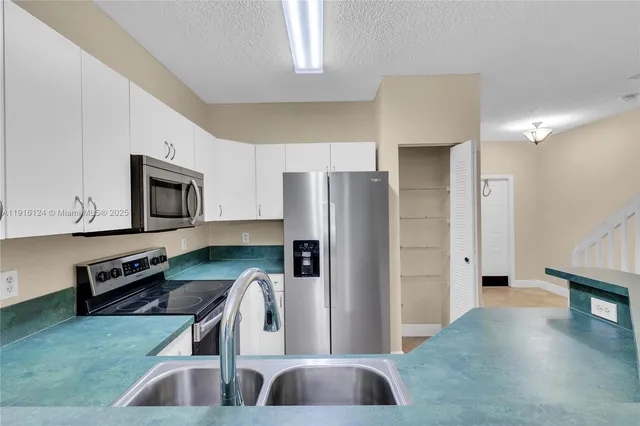 a kitchen with stainless steel appliances granite countertop a refrigerator and a stove