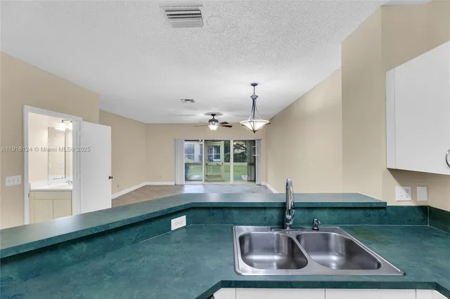 a kitchen with sink window and cabinets
