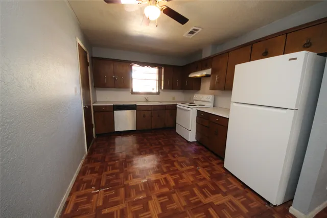 a kitchen with a refrigerator sink and stove