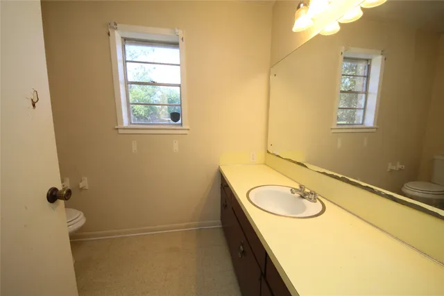 a bathroom with a granite countertop sink mirror and a bathtub