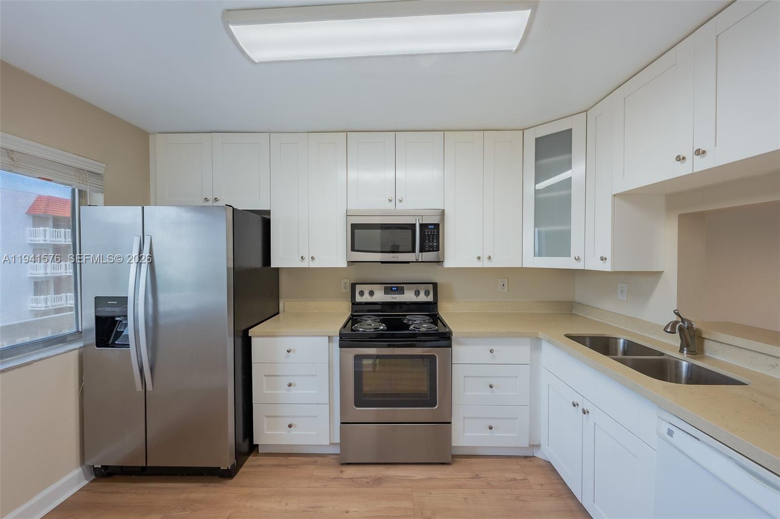 3581 Inverrary Drive, Unit 308 Lauderhill, FL 33319 - Photo 25 of 43 a kitchen with white cabinets and stainless steel appliances