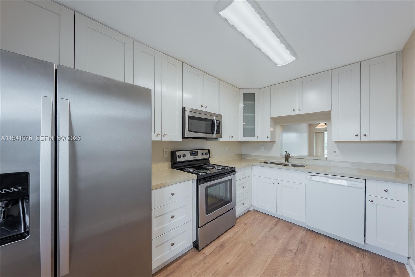 3581 Inverrary Drive, Unit 308 Lauderhill, FL 33319 - Photo 26 of 43 a kitchen with cabinets stainless steel appliances a sink and wooden floor