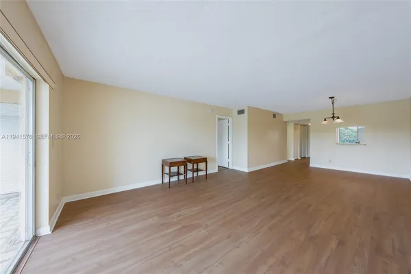 a view of empty room with wooden floor