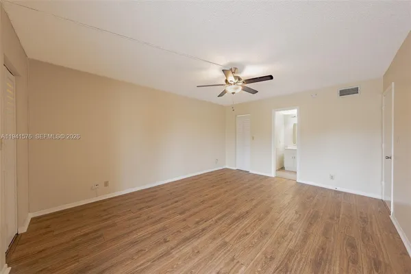 a view of empty room with wooden floor
