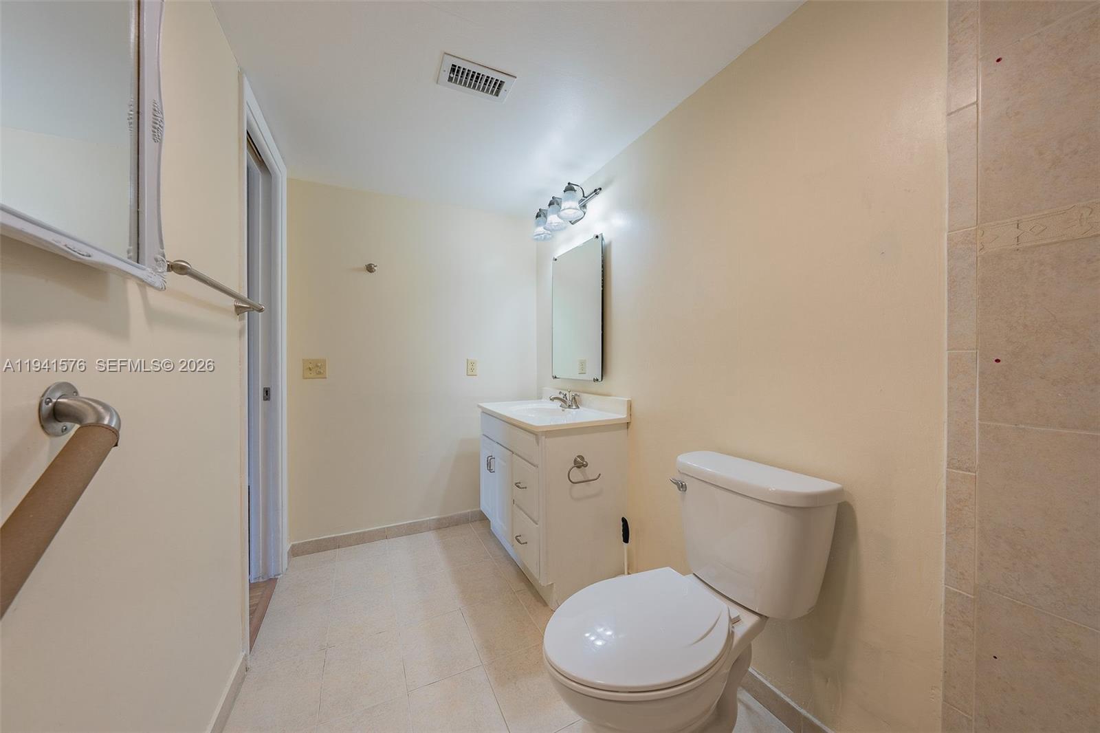 3581 Inverrary Drive, Unit 308 Lauderhill, FL 33319 - Photo 41 of 43 a bathroom with a toilet a sink and mirror