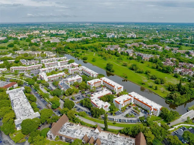 an aerial view of residential houses with outdoor space and trees all around