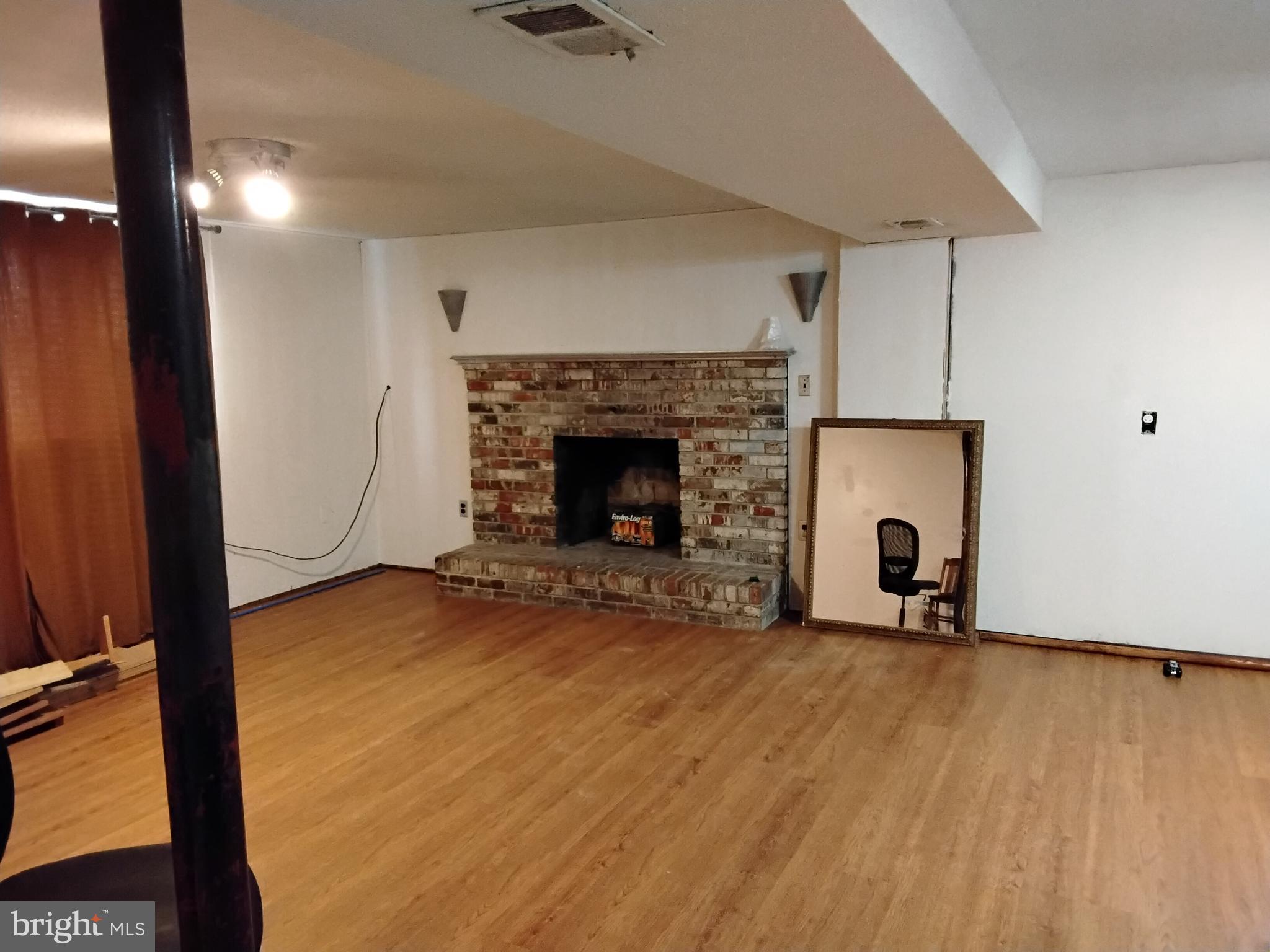 11422 Brandywine Road Clinton, MD 20735 - Photo 3 of 18 a view of an empty room with wooden floor and a fireplace