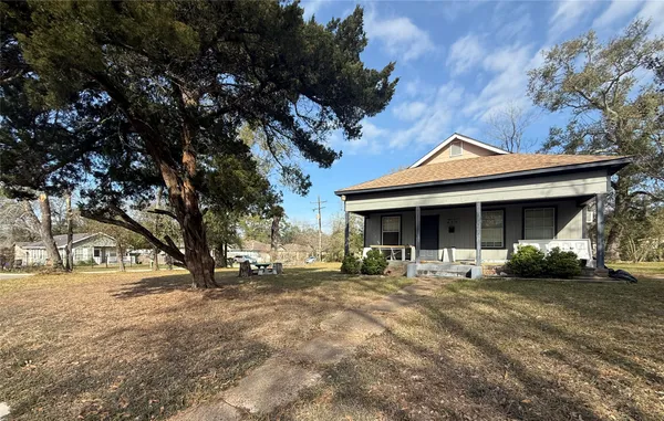 a front view of a house with a yard and trees