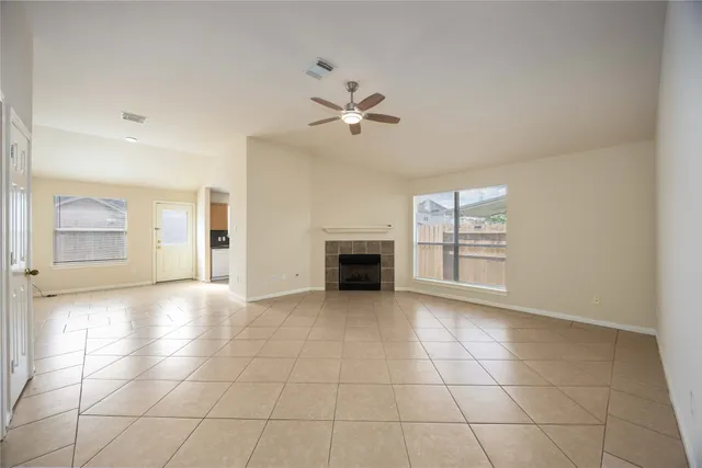 a view of an empty room with a fireplace and a window
