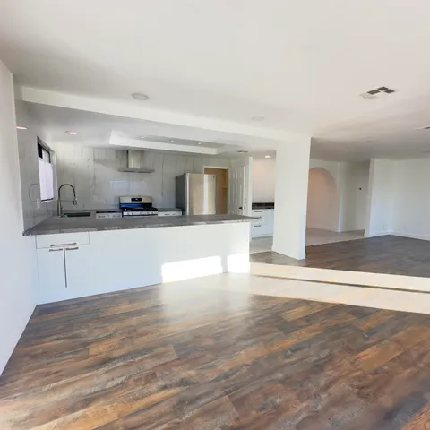a view of a kitchen with kitchen island and stainless steel appliances