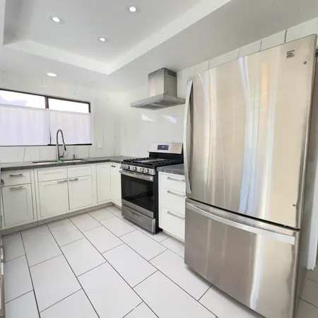 a kitchen with white cabinets and white appliances