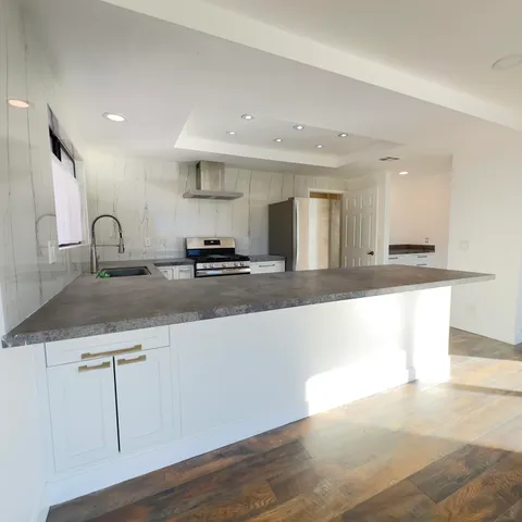 a kitchen with stainless steel appliances granite countertop a sink and a refrigerator