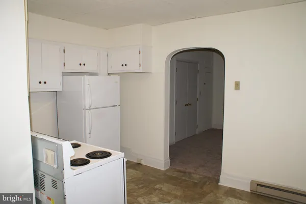 a view of kitchen with a refrigerator and cabinets