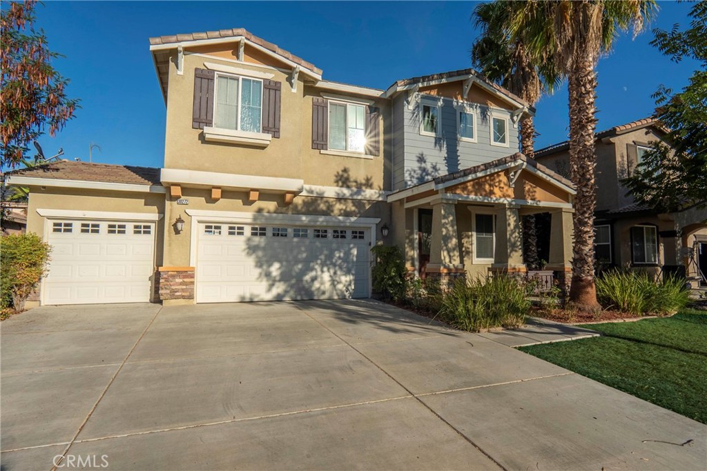 a front view of a house with a garden and trees