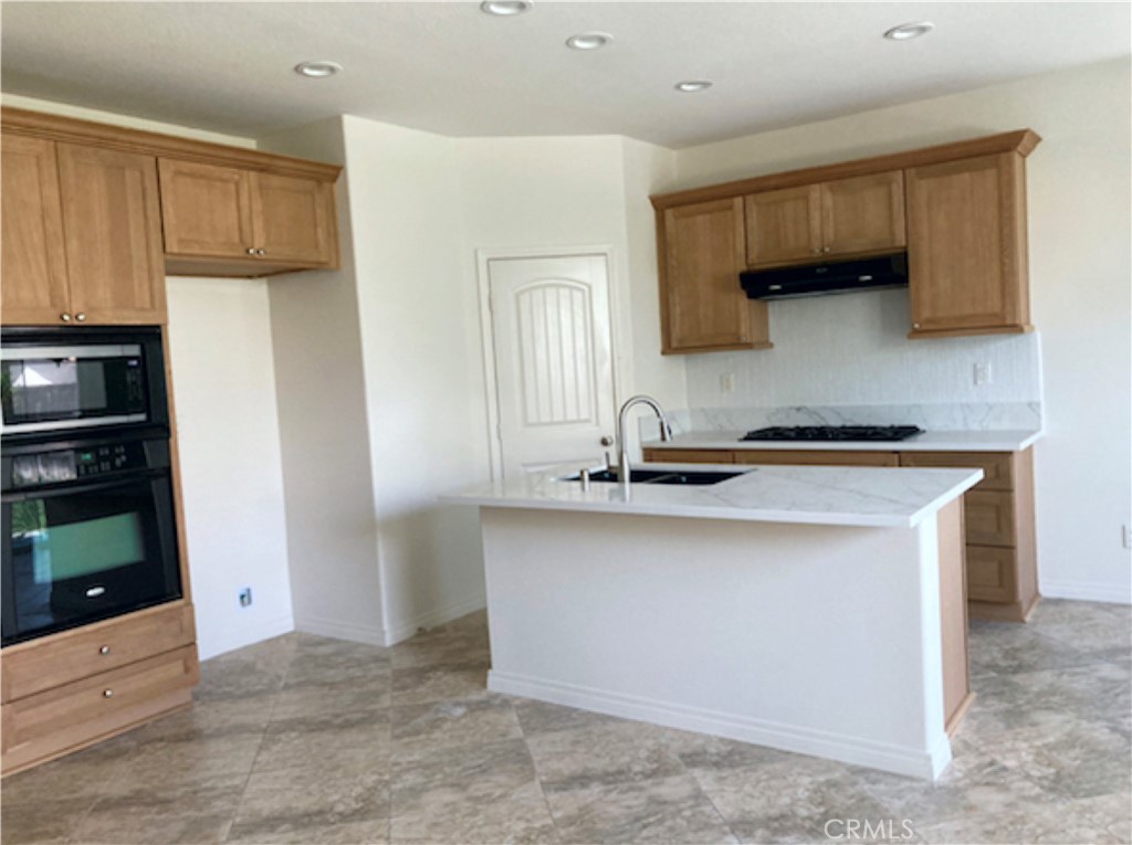 30272 Tattersail Way Menifee, CA 92584 - Photo 8 of 44 a kitchen with stainless steel appliances a sink stove and refrigerator