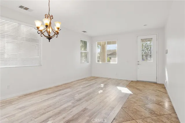 an empty room with a fireplace and ceiling fan