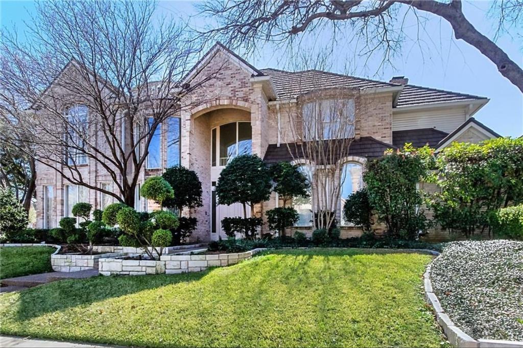View of front of home with a front yard, brick siding, and a chimney