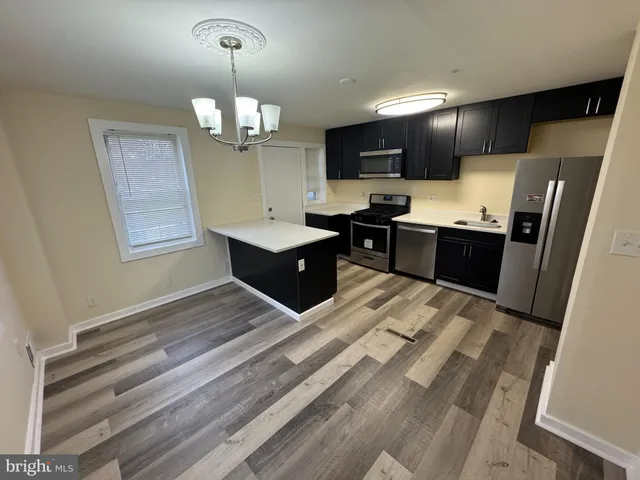 a kitchen with stainless steel appliances granite countertop a sink refrigerator stove and microwave