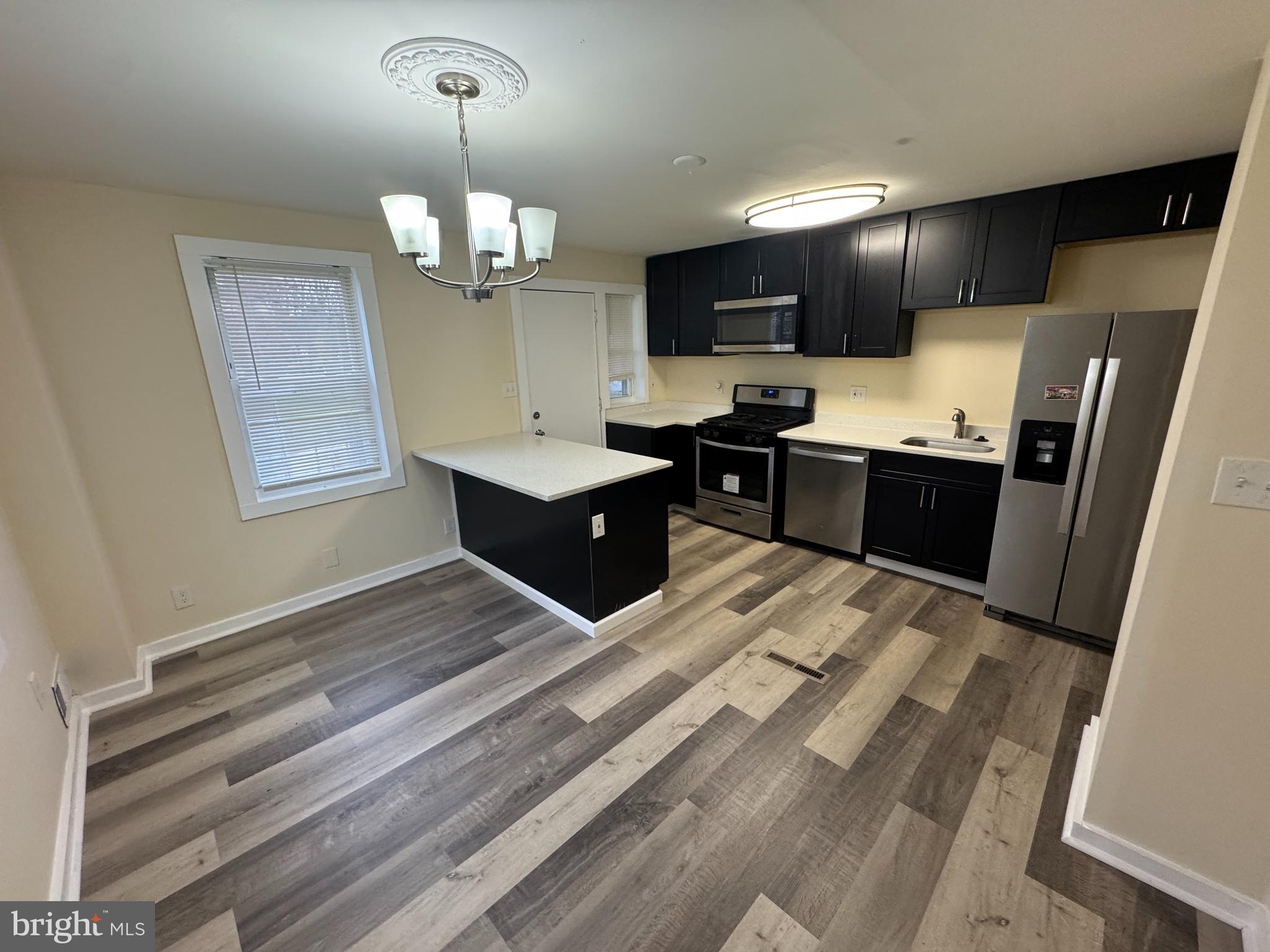 7445 Edsworth Road Baltimore, MD 21222 - Photo 11 of 37 a kitchen with stainless steel appliances granite countertop a sink refrigerator stove and microwave