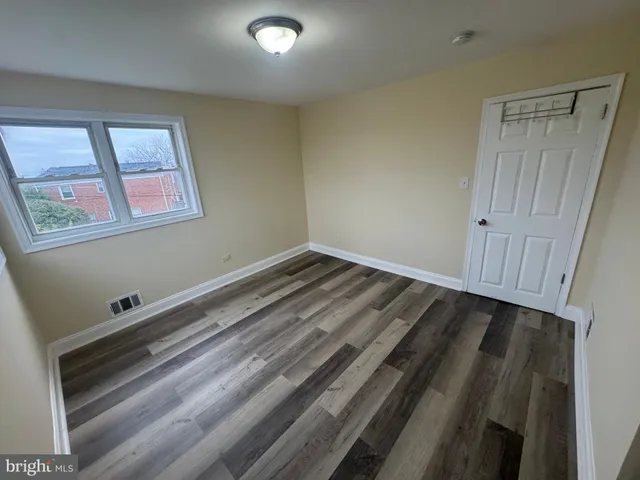 a view of a room with wooden floor and window