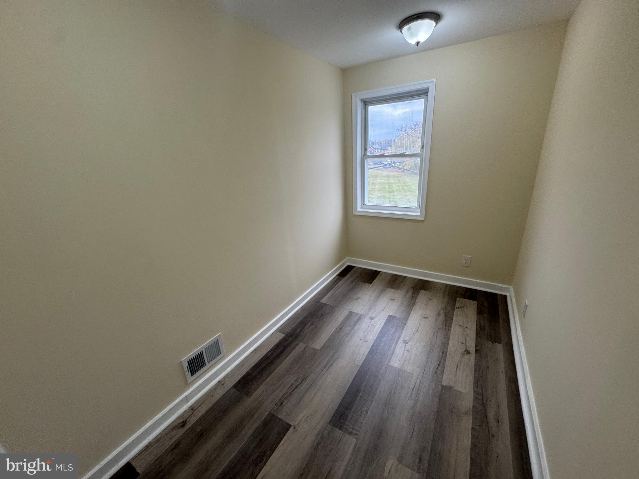 7445 Edsworth Road Baltimore, MD 21222 - Photo 23 of 37 an empty room with wooden floor