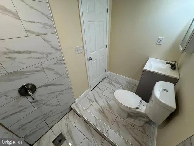 a white toilet sitting next to a shower