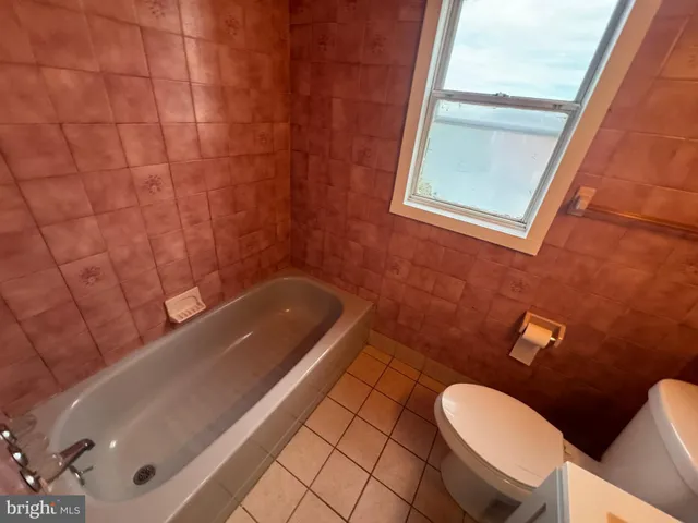 a bathroom with a tub a sink and a toilet