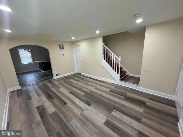 a view of a hallway with wooden floor and staircase