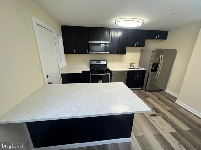 a kitchen with a sink a microwave a refrigerator and cabinets