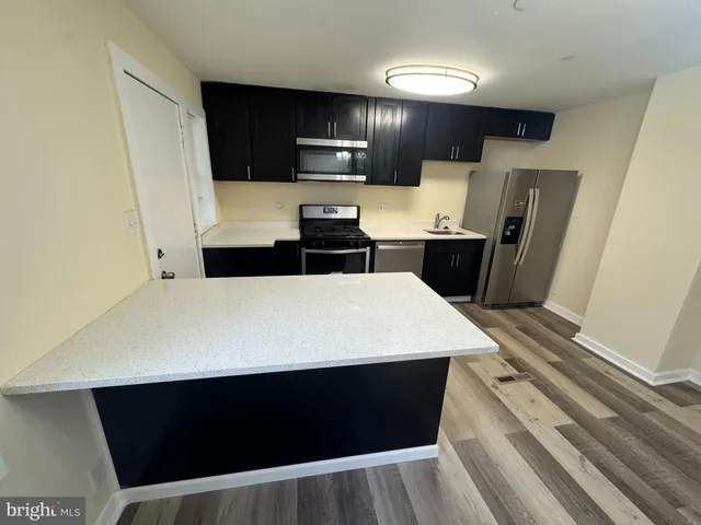 a kitchen with a refrigerator and a stove top oven