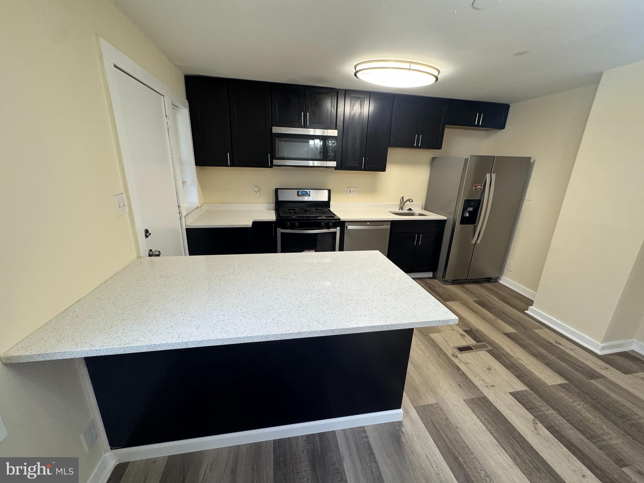 7445 Edsworth Road Baltimore, MD 21222 - Photo 7 of 37 a kitchen with a refrigerator and a stove top oven