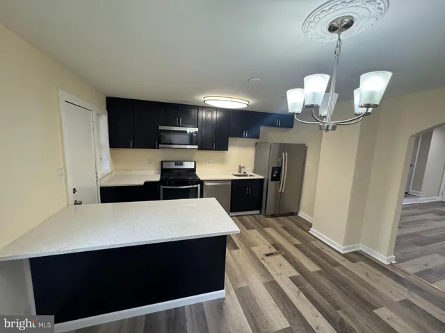 a large kitchen with stainless steel appliances a stove refrigerator and cabinets