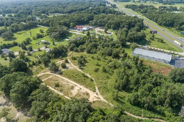an aerial view of residential houses with outdoor space and trees