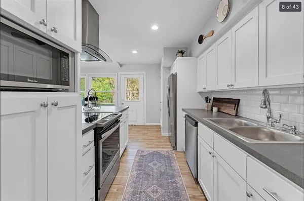 a kitchen with stainless steel appliances granite countertop a sink stove and refrigerator