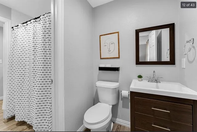 a bathroom with a toilet sink vanity and mirror