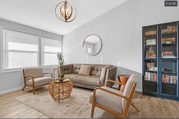 a living room with furniture a bookshelf and a window