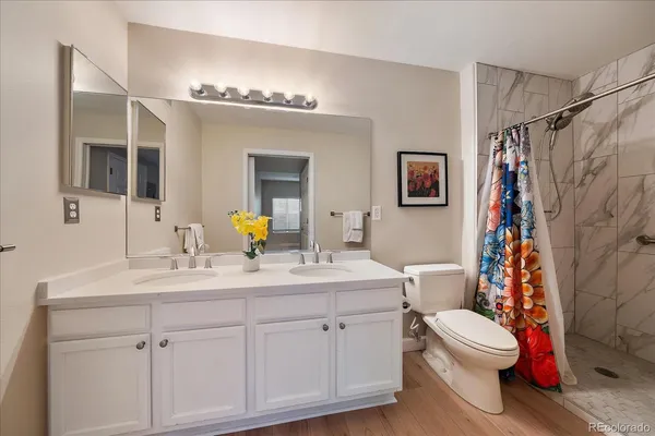 a bathroom with a double vanity sink mirror and toilet